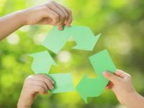 Sustainability Corps Children's hands each holding part of a recycle sign
