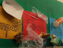 This sign, created by Deal students, hangs in Deal's school cafeteria to inform others about what materials should go in each different collection bin. This sign, created by Deal students, hangs in Deal's school cafeteria to inform others about what materials should go in each different collection bin.