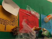 This sign, created by Deal students, hangs in Deal's school cafeteria to inform others about what materials should go in each different collection bin.