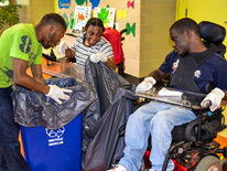 These Sharpe Health students hold a collection bag while another student empties recycling bins into the bag to consolidate the recyclables from around the entire school building.